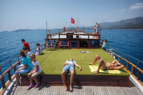 Tourists rest on green deck of  leisure boat trip, Turkey. — Stock Photo, Image