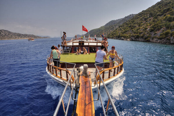 Tourists relax on board excursion yachts in the Mediterranean Sea.