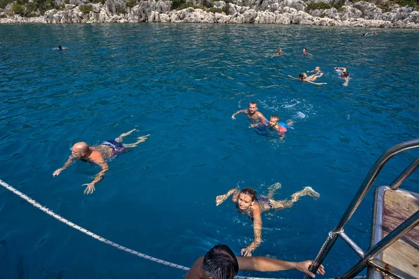 Group of tourists bathes in sea, near the yacht. — Stock Photo, Image