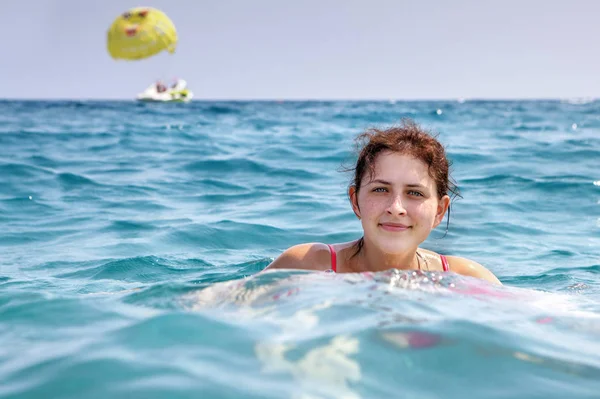 Girl 19 years old, swims in blue sea water alone. — Stock Photo, Image