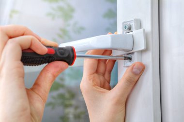 Pencere işleyicisi pvc pencere üzerinde vida vidalama.