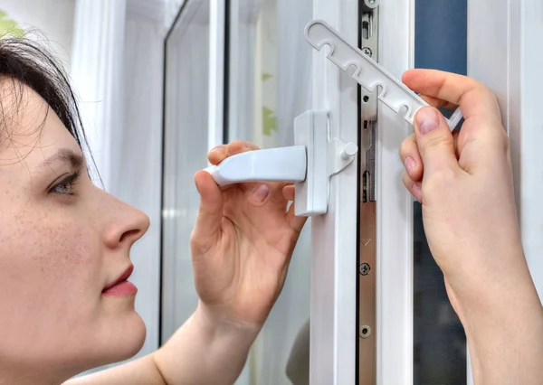 She mounts limiter for tilting and turning on PVC window. — Stock Photo, Image