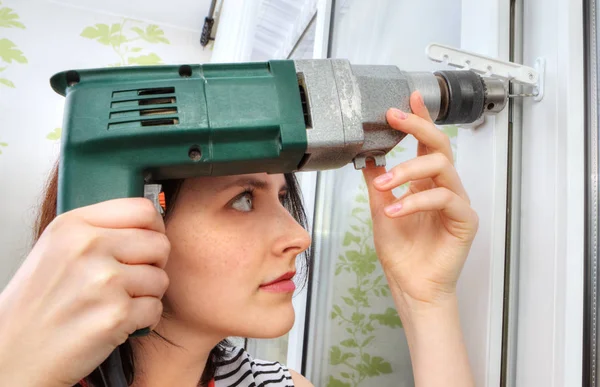 She does fixing holes for window limiter using an drill. — Stock Photo, Image