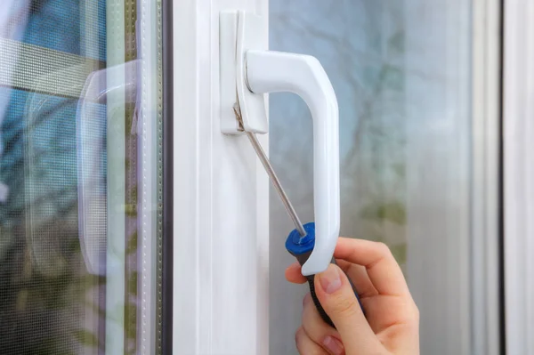 Removing handle of a plastic window using hand screwdriver. — Stock Image Removing handle of a plastic window using hand screwdriver. Stock Image