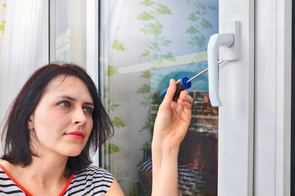 Girl parses the handle for PVC window using a screwdriver. — Stock Image Girl parses the handle for PVC window using a screwdriver. Royalty Free Stock Photos