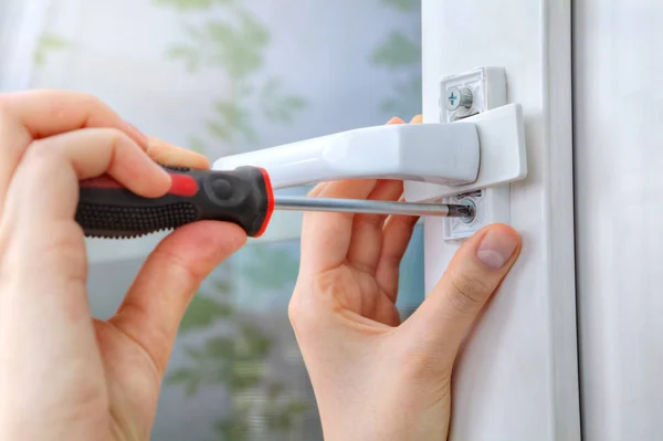 Screwing the screw of window handle on pvc window. — Stock Image Screwing the screw of window handle on pvc window. Royalty Free Stock Photos