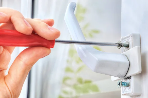 Hand unscrews the bolt, using a screwdriver, dismantling window — Stock Image Hand unscrews the bolt, using a screwdriver, dismantling window Royalty Free Stock Photos