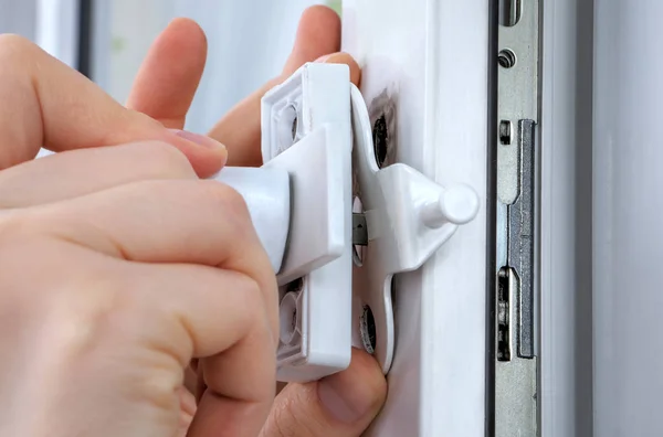 Close-up hands of locksmith installing window limiter on plasti — Stock Image Close-up hands of locksmith installing window limiter on plasti Stock Picture