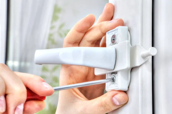 Hand with screwdriver tightens fixing screw of window restricto — Stock Image Hand with screwdriver tightens fixing screw of window restricto Stock Picture