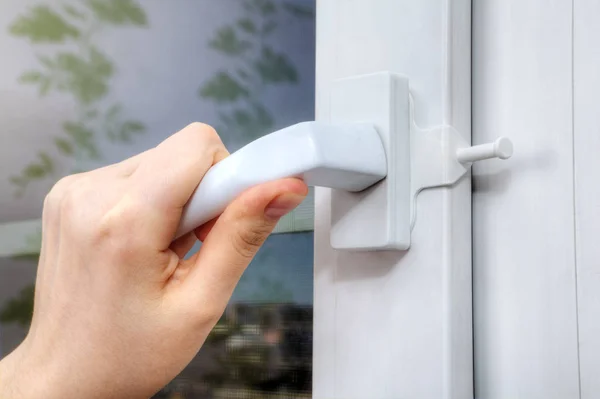 Hands turning handle of plastic window on which opening delimite — Stock Image Hands turning handle of plastic window on which opening delimite Stock Photo