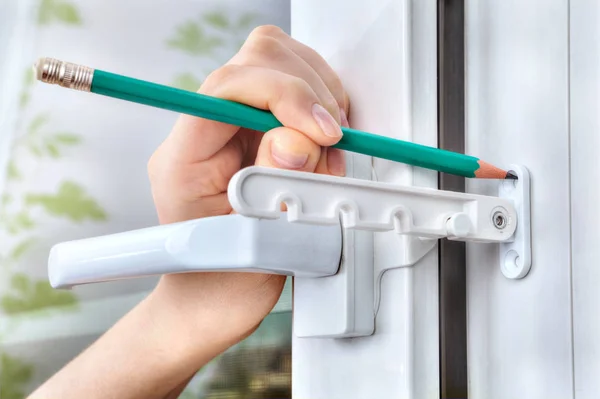 Marking holes for fixing tilt restrictor PVC window. — Stock Image Marking holes for fixing tilt restrictor PVC window. Stock Photo