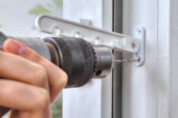 Close-up of drill that drills a hole in PVC window. — Stock Image Close-up of drill that drills a hole in PVC window. Royalty Free Stock Images