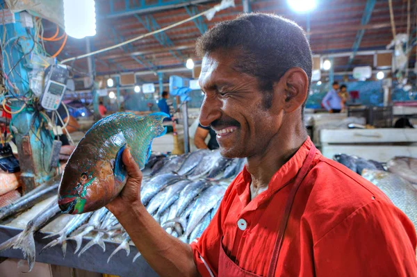 İranlı bir adam elinde bir balıkla güler. — Stok fotoğraf