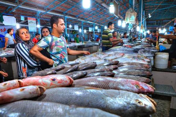 Clientes muçulmanos escolhem peixe fresco no mercado coberto . — Fotografia de Stock