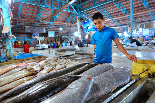 Αγόρι πωλητής δείχνει φρέσκο ψάρι στην εσωτερική ψαραγορά. — Φωτογραφία Αρχείου