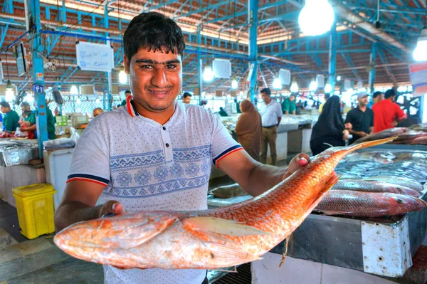 Perski-człowiek posiada duże ryby w zadaszony rynek. — Zdjęcie stockowe