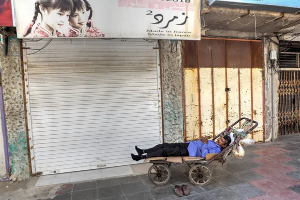 One persian male loader sleeps in a hand trolley. — Stock Photo, Image