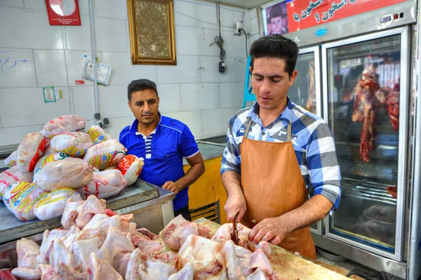Irański rzeźnik tnie tusze kurczaka o rzezi sklep. — Zdjęcie stockowe