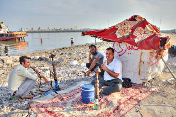 Hombres iraníes fuman narguile en la orilla del Golfo Pérsico . — Foto de Stock