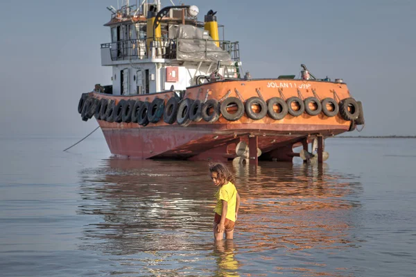 Een meisje loopt knieën in het zeewater, zuidelijk Iran. — Stockfoto