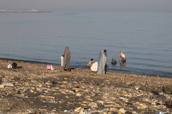 Mehrere islamische Frauen in Hijabs schwimmen mit Kindern im Meer. — Stockfoto