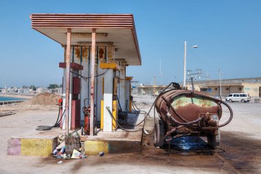 Paslı araba tank küçük bir benzin istasyonu yakınında standları.
