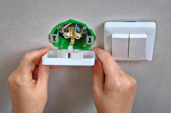 Fijación de enchufe de pared eléctrico e interruptor de luz, electricista han — Foto de Stock