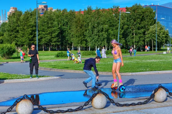 Cameraman makes a video of the girl riding on gyroscooter. — Stock Photo, Image