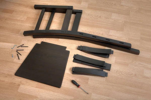 Pièces de chaise en bois, des outils et des attaches se trouvent sur le sol . — Photo
