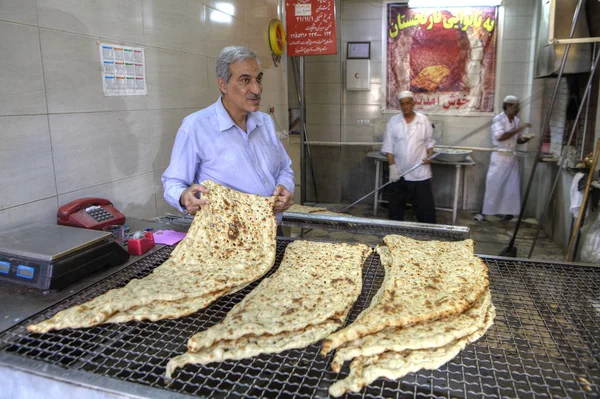 Verkäufer erwägt frisch gebackenes Fladenbrot in traditionellem iranischen Brot Lavasch. — Stockfoto