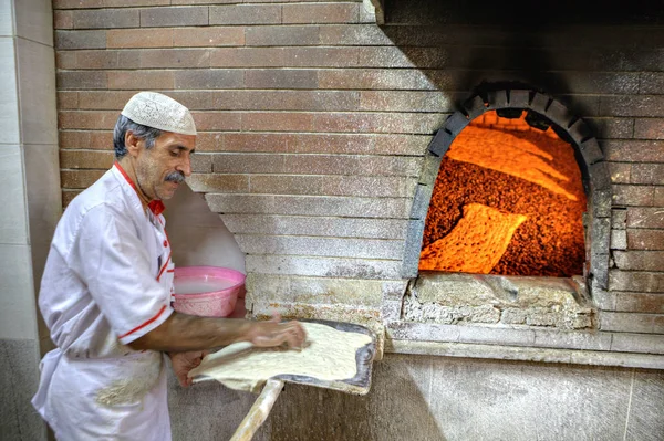Baker hamur fırında göndermek için kürek üzerinde sundu.