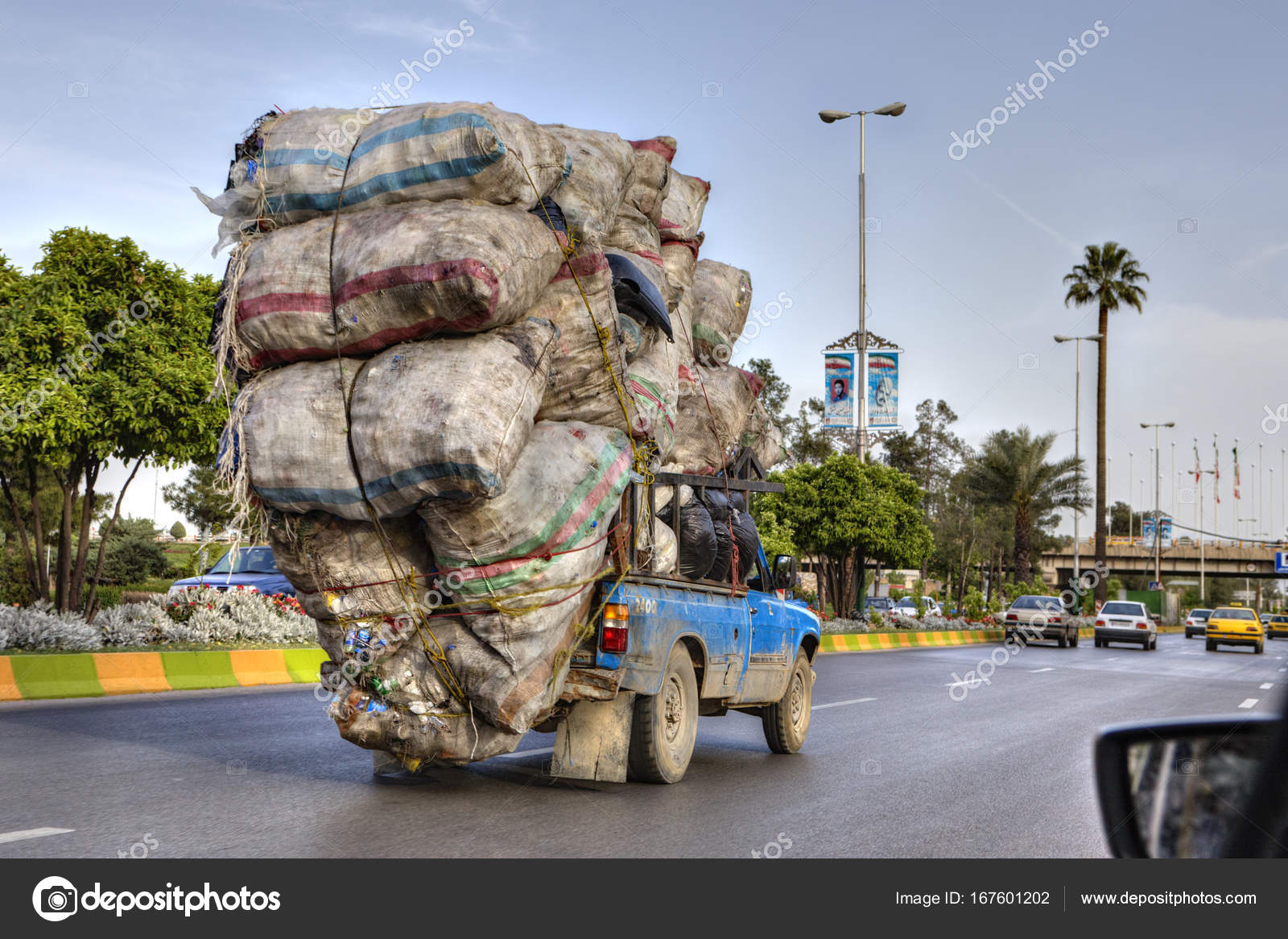 Overloaded with bags of waste, vehicle moves on higway, Shiraz, Iran. –  Stock Editorial Photo © grigvovan #167601202