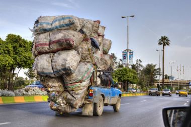 Atık torbaları ile aşırı, araç yolu üzerinde Şiraz, Iran taşır.