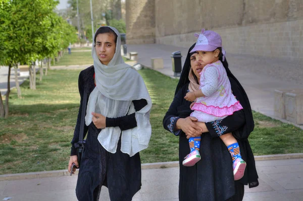 Två Muselman kvinnor i hijabs är walking med en barn, Shiraz, Iran. — Stockfoto