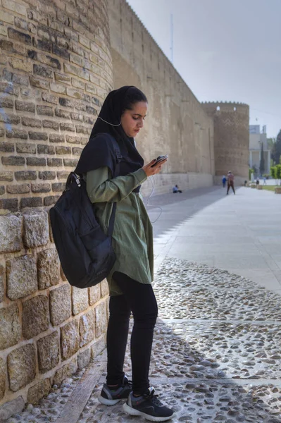 Mädchen im Hijab hören Musik vom Smartphone über Kopfhörer, Shiraz, Iran. — Stockfoto