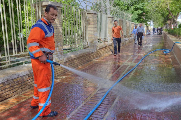Οδός σκούπα χρήσεις νερού υπό πίεση για πλύσεις πεζοδρόμιο, Σιράζ, Ιράν. — Φωτογραφία Αρχείου