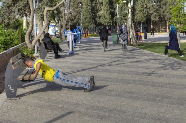 Sabah sporu parkta, olgun bir adamın şınav çekmesi, Şiraz, İran.