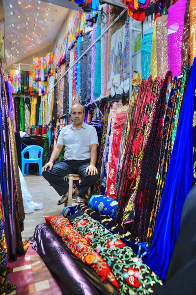 伊朗推销员坐在中间彩色织物在纺织车间，伊朗设拉子. — 图库照片