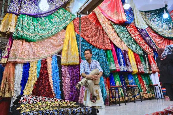 Μοναχικός έμπορος κάθεται στο έδρανο οχυρού στην κλωστοϋφαντουργία τμήμα στο παζάρι, Σιράζ, Ιράν. — Φωτογραφία Αρχείου