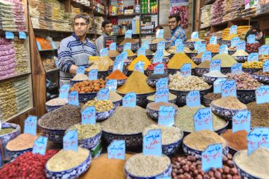 Baharatlar, tohum ve kuru meyve, vitrin, Şiraz, Iran yanında duran satıcı.