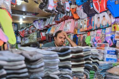 Underwear store inside bazaar, Iranian seller waiting for buyers, Shiraz, Iran. clipart