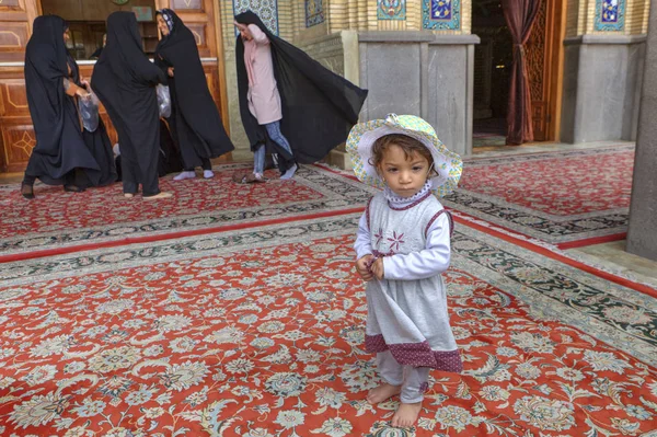 Piccola ragazza iraniana vicino alle donne in abiti neri musulmani, Shiraz, Iran . — Foto Stock