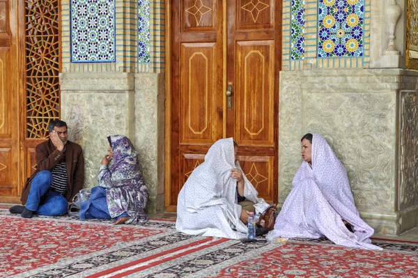 Cemaat Şah Cheragh Camii, Şiraz, Iran avluda oturup.