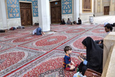 Çocuk ile İslam kadın Camii, Şiraz, Iran avluda oturuyor.