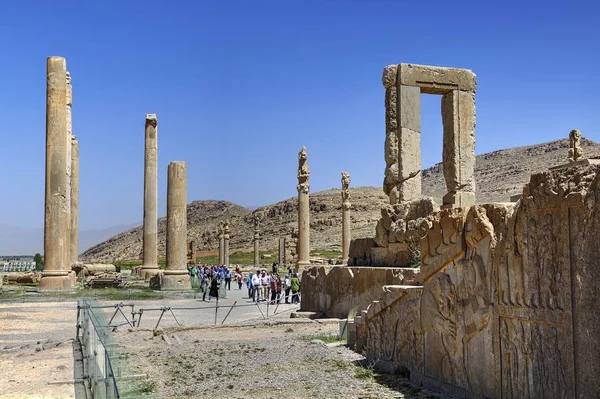 Turisták elsétálnak pillére, a romok az ősi Persepolis közelében az iráni Shiraz. — Stock Fotó