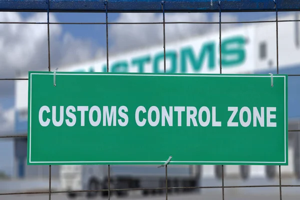 Green sign, customs control zone, on fence of logistic terminal.