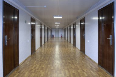 Uzun office koridor ile birçok kapı koyu kırmızı ahşap.