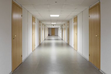 Empty office corridor with many doors of light wood. clipart