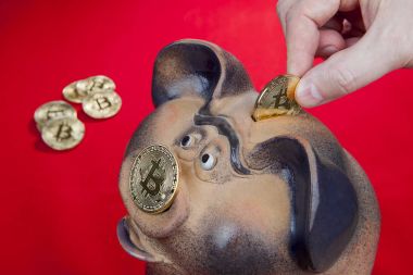 Portre, insan eli para bitcoin kumbara yuvasına düşürür.