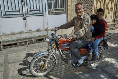 Aile üç İranlılar motosiklet üzerinde şehir sokak biniyor.